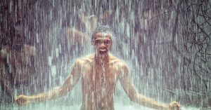 A guy standing underneath a waterfall while swimming | Goldstein Chrysler Jeep Dodge RAM