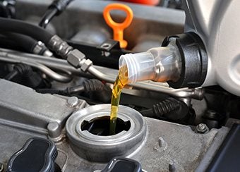 Pouring clean oil into a car during an oil change in Latham, NY | Goldstein Chrysler Jeep Dodge RAM