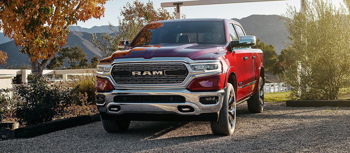 New 2022 RAM 1500 Truck, red color in a country setting